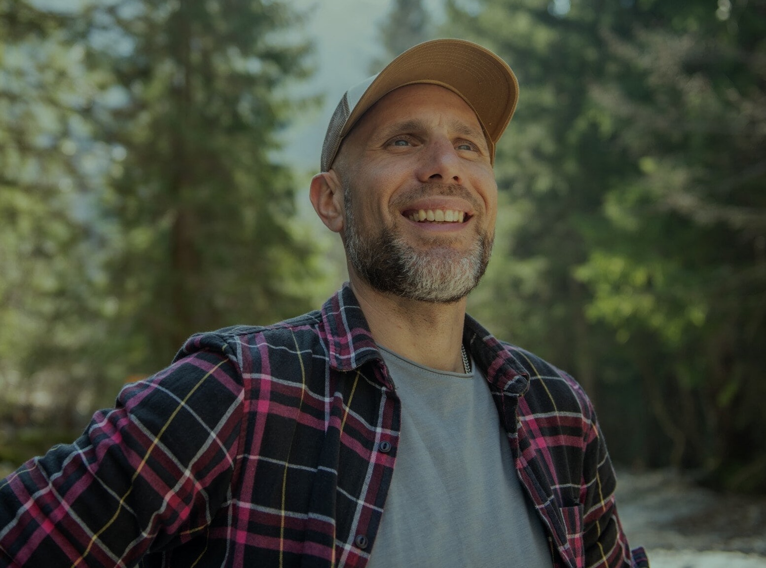 en man med leende på läpparna ute i skogen